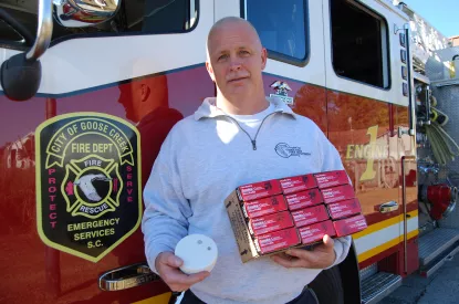 GCFD Captain Todd Pruitt holding smoke detectors